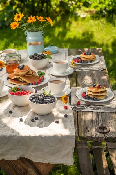 Pancakes with raspberries and blueberries in summer garden — Stock Photo, Image