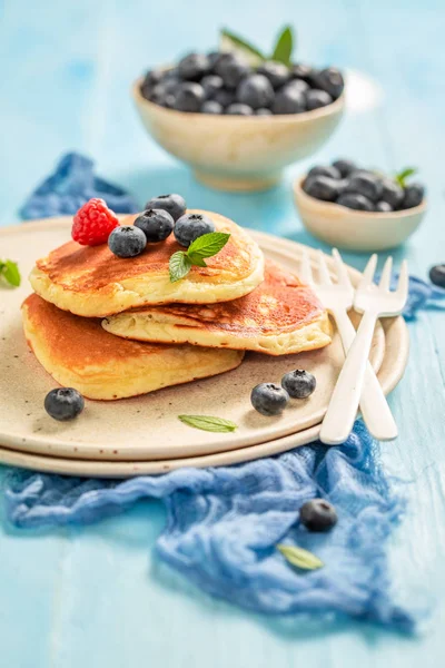 Panqueques americanos con arándanos frescos y azúcar en la mesa azul — Foto de Stock