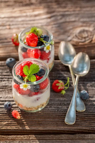 Closeup of oat flakes with berries and yoghurt in jar — Stock Photo, Image