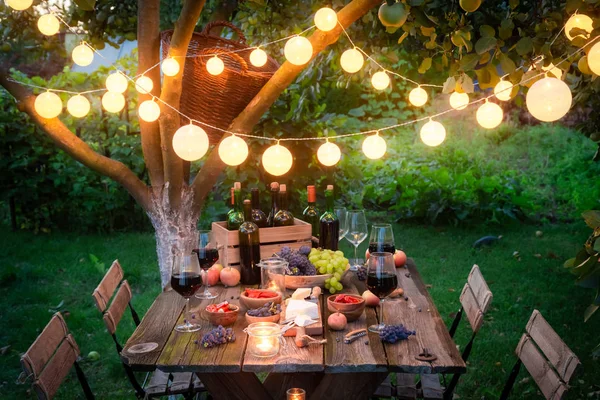 Rustieke tafel met hapjes en wijn in de zomeravond — Stockfoto