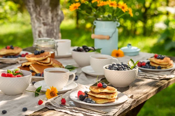 Hausgemachte Pfannkuchen serviert mit Kaffee im Sommergarten — Stockfoto