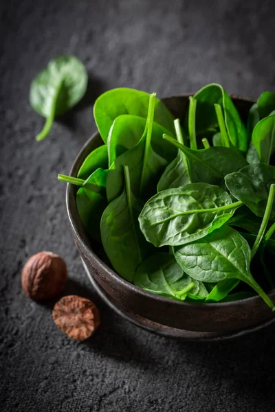 Raw green spinach in small rustic brown bowl — Stock Photo, Image