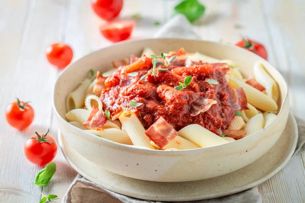 Delicious penne bolognese with herbs and bacon — Stock Photo, Image