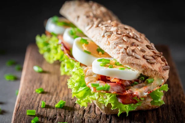 Ízletes szendvics fejes saláta, tojás, bacon — Stock Fotó