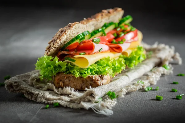 Delicioso sanduíche com presunto, alface e cebolinha para o café da manhã — Fotografia de Stock