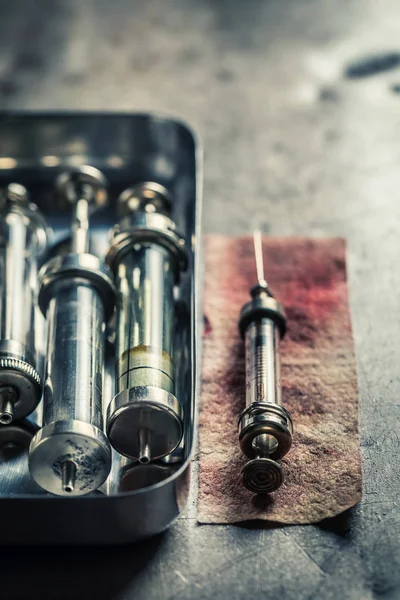 Classic syringes with a needle prepared on red bandage — Stock Photo, Image