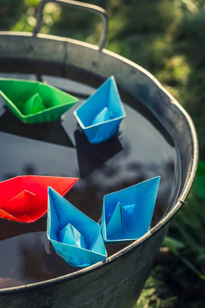 Barcos de papel a color hechos a mano en el agua como concepto de viaje —  Fotos de Stock