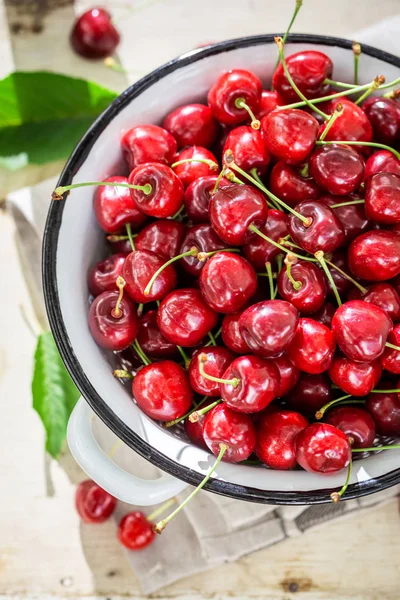 Fresh and tasty sweet cherries on the white old strainer — Stock Photo, Image