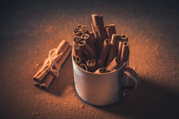 Top view of cinnamon bark and powder in metal mug — Stock Photo, Image