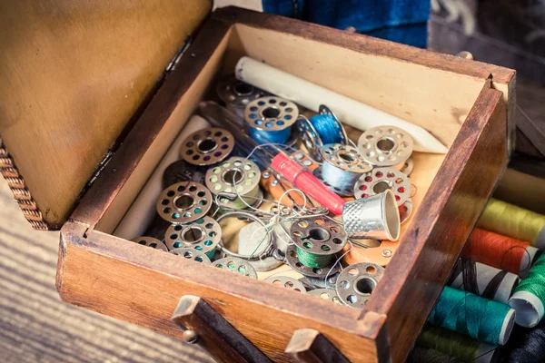 Fechar a caixa de madeira do alfaiate com fios coloridos e agulhas — Fotografia de Stock