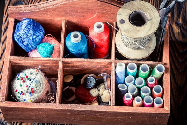 Roscas, agulhas e botões em caixa de madeira sob medida — Fotografia de Stock