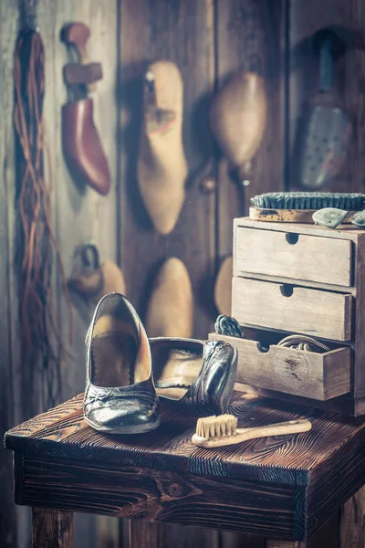 Atelier de cordonnier rustique avec chaussures et brosse — Photo