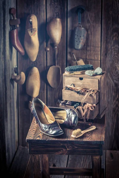 Oficina sapateiro rústico com sapatos, ferramentas e cadarços — Fotografia de Stock