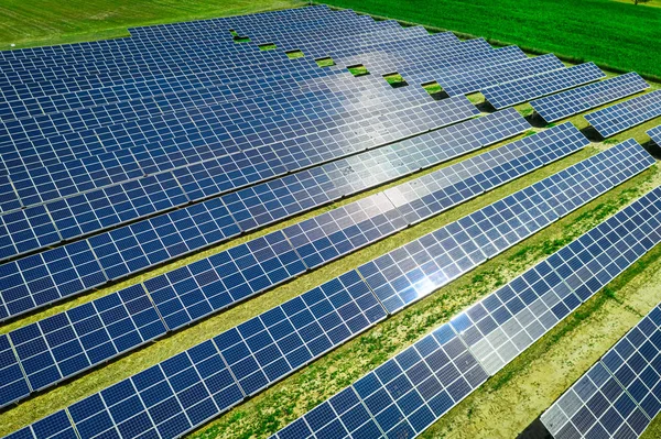 Painéis solares no campo verde com céu azul, vista aérea — Fotografia de Stock