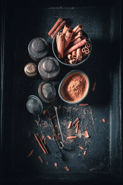 Montón de palitos de canela en una taza oscura —  Fotos de Stock
