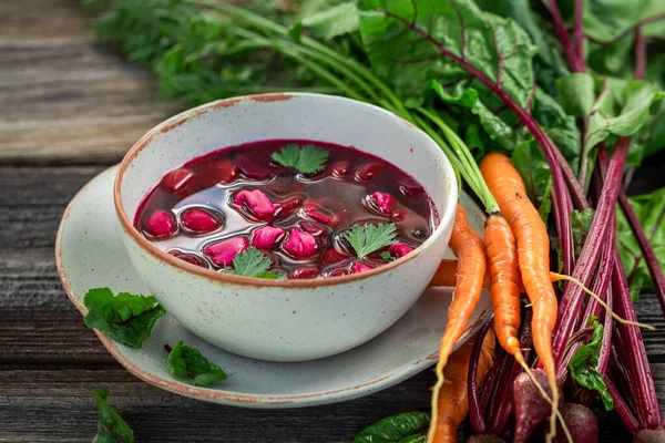 Closeup of beetroot soup with dumplings on wooden table — Stock Photo, Image