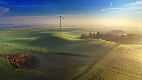Impresionante amanecer brumoso en el campo con turbina eólica — Vídeos de Stock