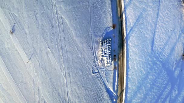 Estrada e feno bolas no campo nevado, vista aérea de inverno — Vídeo de Stock