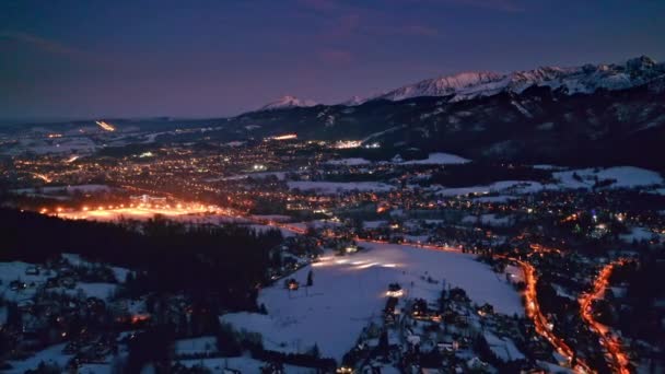 Ciudad iluminada de Zakopane por la noche en invierno, vista aérea — Vídeo de stock