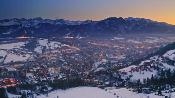 Atardecer sobre la ciudad de zakopane en invierno por la noche, vista aérea — Vídeo de stock