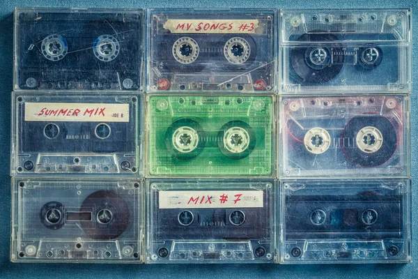 Retro audio cassettes arranged in a grid on blue sofa