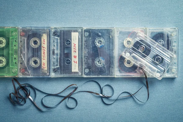 Várias Cassetes Áudio Antigas Com Uma Fita Extraída Mesa Azul — Fotografia de Stock