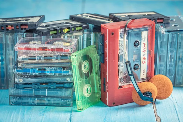 蓝色桌子上有收音机和耳机的旧盒式磁带 — 图库照片