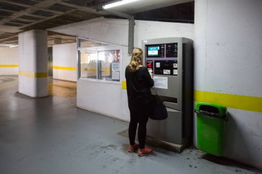 Kamu garajında ödeme yapan bir kadın.