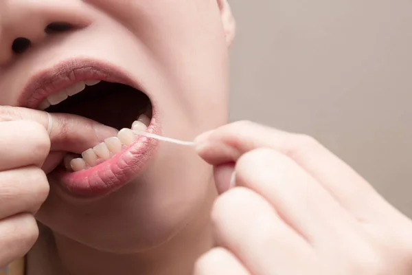 Asyalı kadın gıda ve dental plak dişlerin arasından alanlarda kaldırmak için diş fırçası diş ipi kullanma ulaşamıyoruz