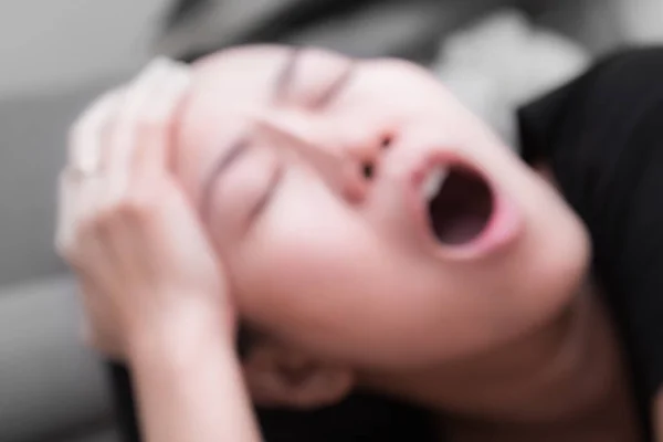 彼女の頭を保持している若いアジア女性のぼやけてフォーカスが強い頭痛と発熱を有する苦しむ — ストック写真