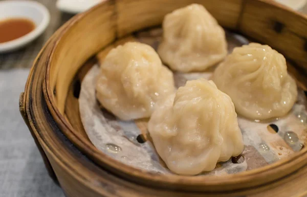 stock image Xiao Long Pao in small bamboo steaming basket, Type of Chinese steamed bun filled with lobster, crab meat and soup inside