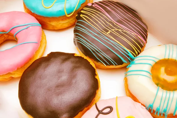 Variety of donuts and Boston cream pie or Chocolate donuts without a hole, ready to eat on delivery box