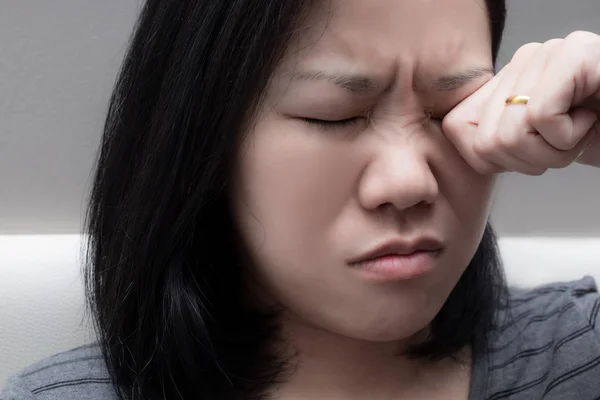 Asian woman rubbing her eye. because of eye\'s problem, dust allergy, dry eye, watery, itching or contact lenses problem