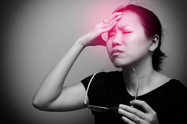 眼鏡をかけているアジアの女性は 強い頭痛と発熱 視力の悪さ 近視に苦しんでいます 彼女の頭の上に赤い斑点を持つ黒と白のトーン — ストック写真