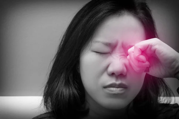 Asian woman rubbing her eye. Black and white tone and red spot on her eyes. Concept of eye\'s problem, dust allergy, dry eye, watery, itching or contact lenses problem