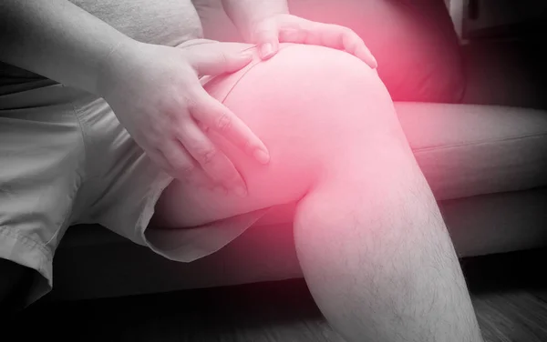 膝の痛みに苦しむ太った男 太りすぎの痛み ヘルスケア 総膝の交換 膝の上に赤い斑点のある黒と白のトーン — ストック写真