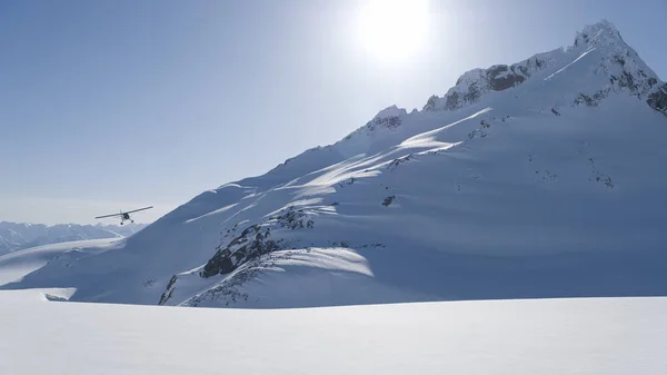 Μικρό Αεροπλάνο Skiis Ετοιμάζεται Προσγειωθεί Ένα Πεδίο Χιονιού Στα Βουνά — Φωτογραφία Αρχείου