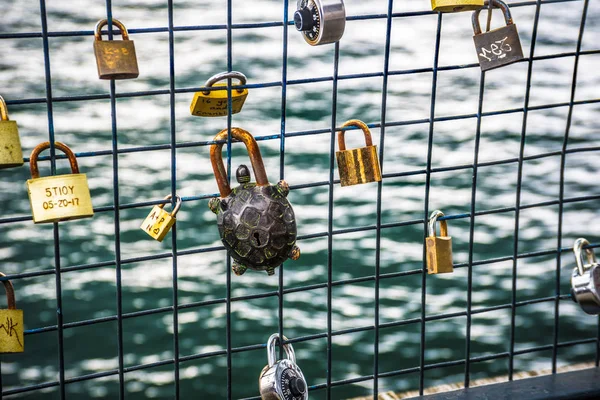 Love padlocks in a bridge with sea in background