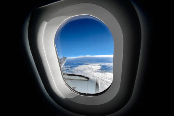 从飞机飞越云层的窗户可以清楚地看到云层和天空 — 图库照片