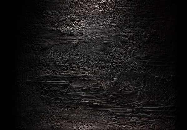 Grungy dark stucco wall with spotlight