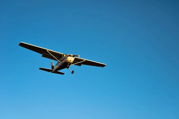 Small airplane approaching with blue sky