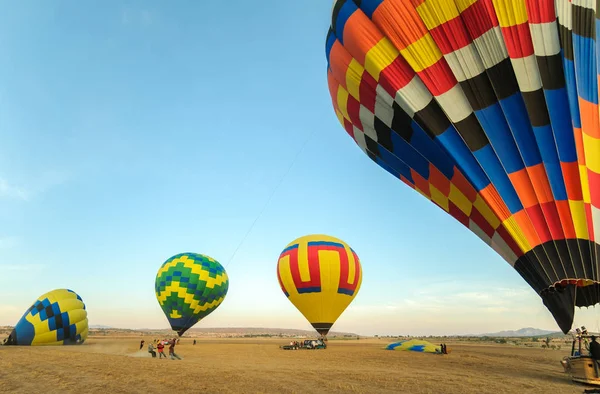 Bunter Heißluftballon mit blauem Himmel hebt bei Sonnenaufgang ab — Stockfoto