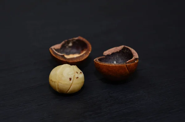 Macadamia nuts on black wooden background