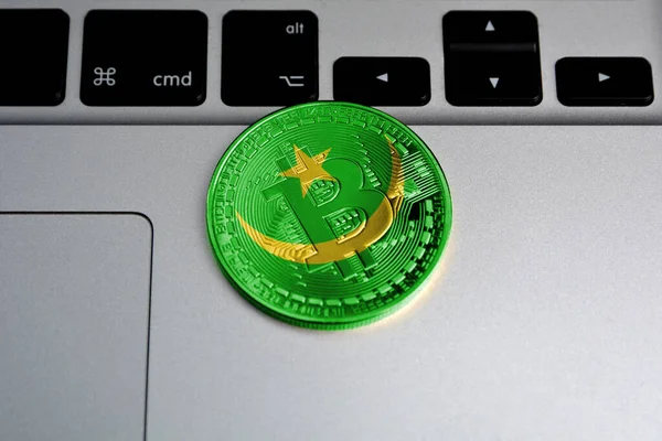 Bitcoin on keyboard background, the flag of Mauritania is shown on bitcoin