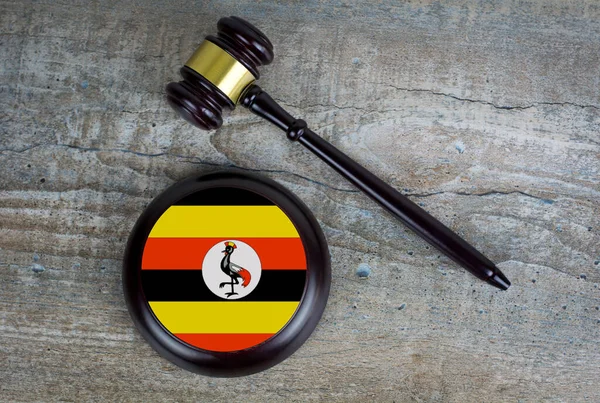 Wooden judgement or auction mallet with of Uganda flag. Conceptual image