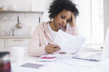 Mutfak masasında aile bütçesine yönetirken duygu genç Afro-Amerikan erkek ciddi mali sorunları vurguladı