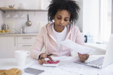 Nasıl borç ödemek düşünme aile içi dudget, analiz etmek çalışıyorum masraflar, hesaplama mutfak masada oturan genç tek Afro-Amerikan kız öğrenci kapalı bir kadeh. Finansal Okuryazarlık kavramı. 