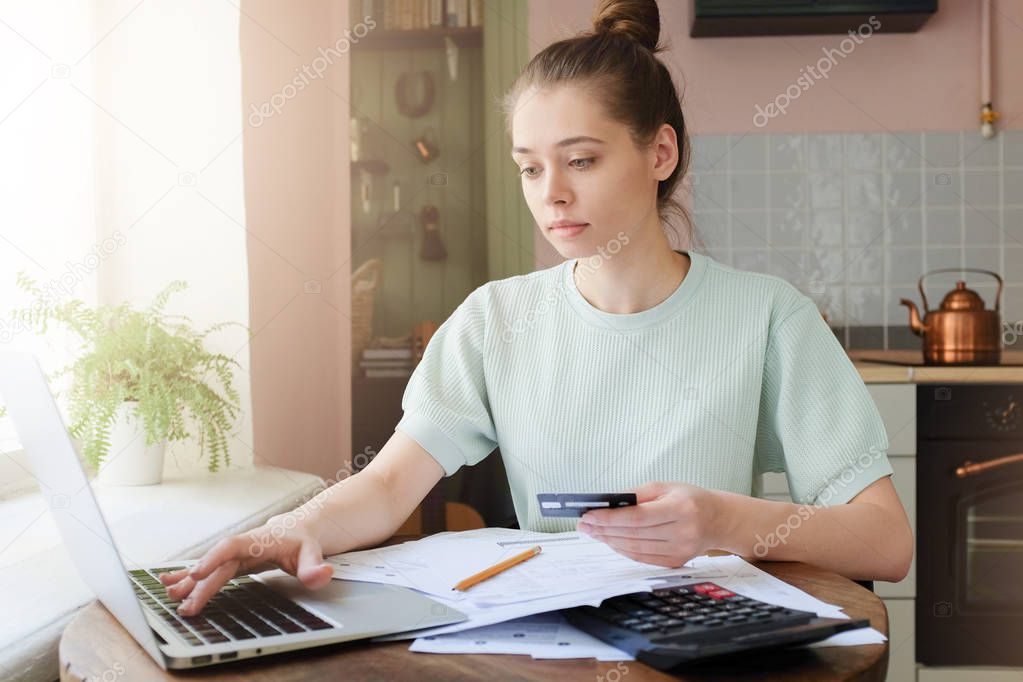 Young beautiful woman paying taxes with credit card