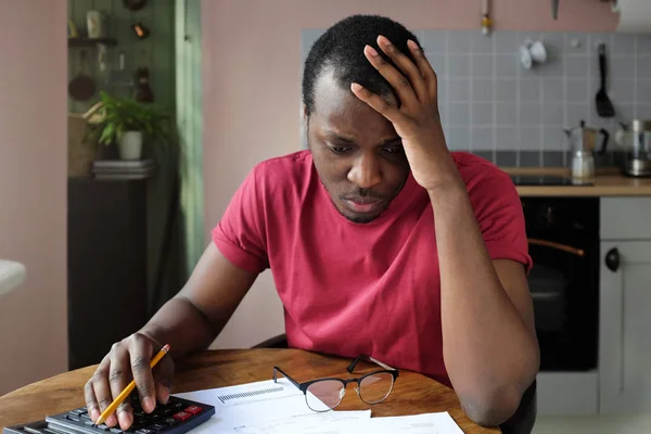 年轻焦虑不安的非洲裔美国人拼命地看账单 面临纳税问题 一手拿着头 — 图库照片