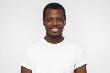 Afro-Amerikan yakışıklı gri arka plan üzerinde izole boş beyaz t gömlek gülümseyen portresi kapatın